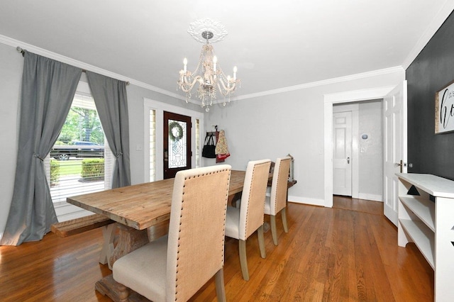 dining space with a notable chandelier, ornamental molding, and dark wood-type flooring