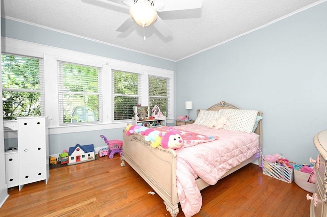 bedroom featuring hardwood / wood-style flooring, ceiling fan, crown molding, and a textured ceiling