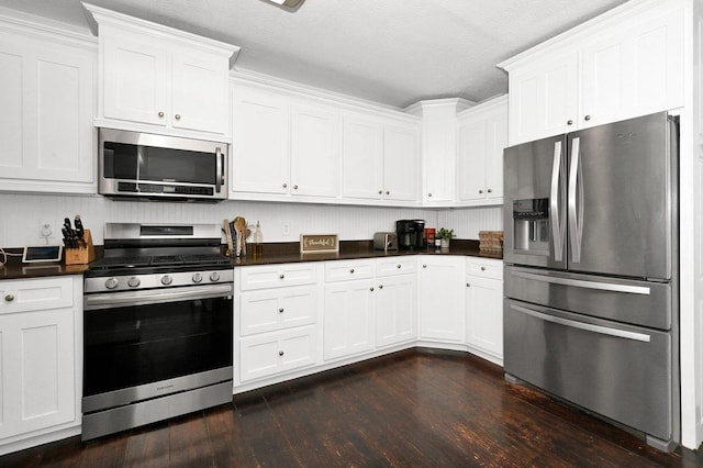 kitchen featuring white cabinets, dark hardwood / wood-style flooring, a textured ceiling, and appliances with stainless steel finishes