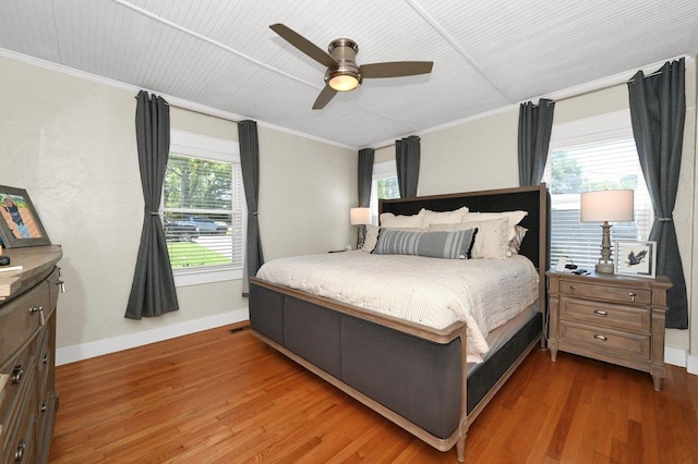 bedroom with hardwood / wood-style floors, ceiling fan, and ornamental molding