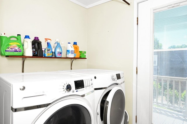 laundry area featuring plenty of natural light, crown molding, and washing machine and clothes dryer