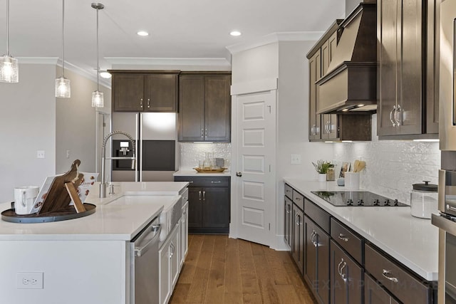 kitchen with hanging light fixtures, dark hardwood / wood-style floors, backsplash, stainless steel fridge, and custom range hood