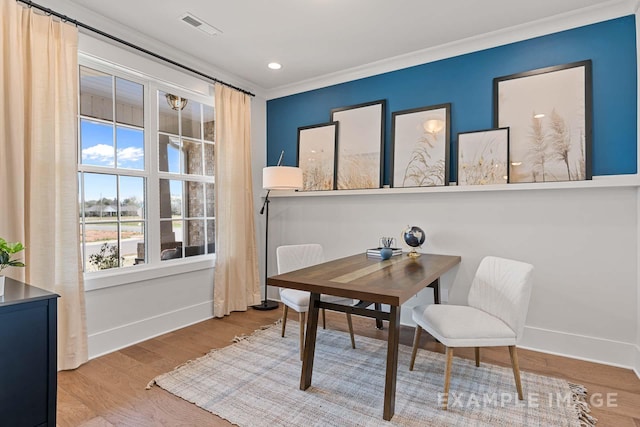 dining room featuring crown molding and light wood-type flooring