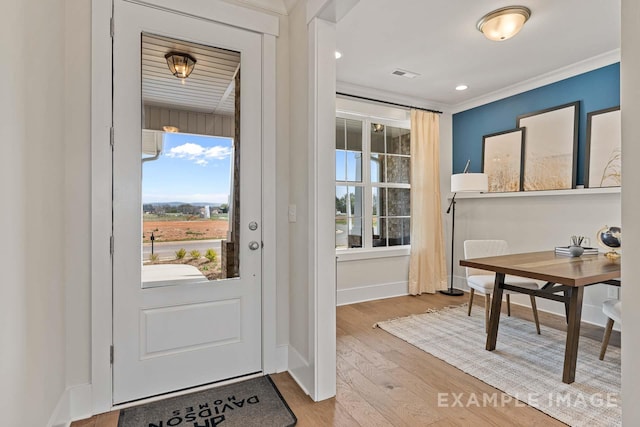 doorway with crown molding and light hardwood / wood-style flooring