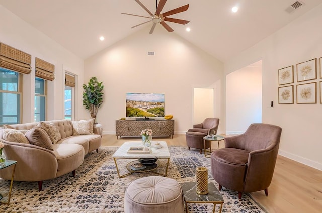 living room featuring ceiling fan, high vaulted ceiling, and light wood-type flooring