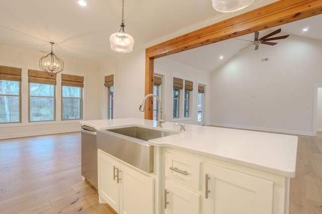 kitchen featuring hanging light fixtures, light wood-type flooring, sink, and stainless steel dishwasher