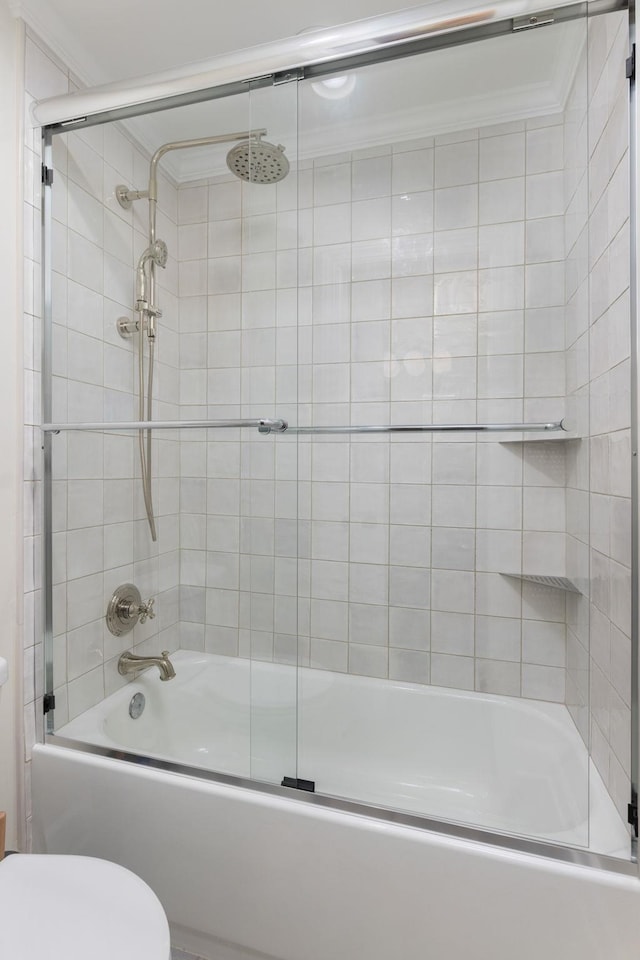 bathroom featuring toilet, shower / bath combination with glass door, and crown molding