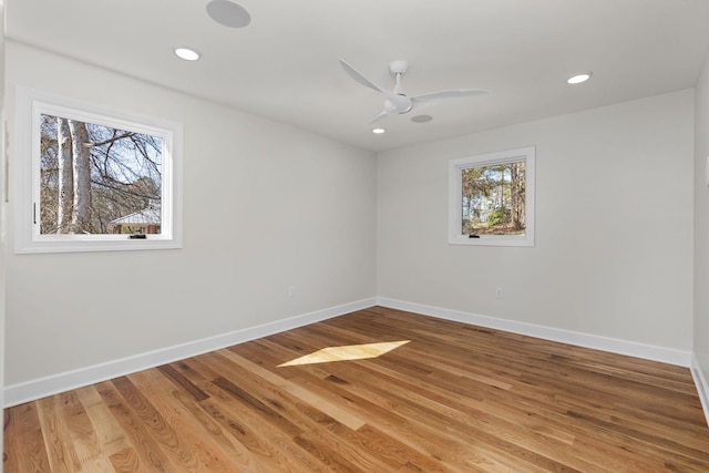 empty room with recessed lighting, wood finished floors, and baseboards