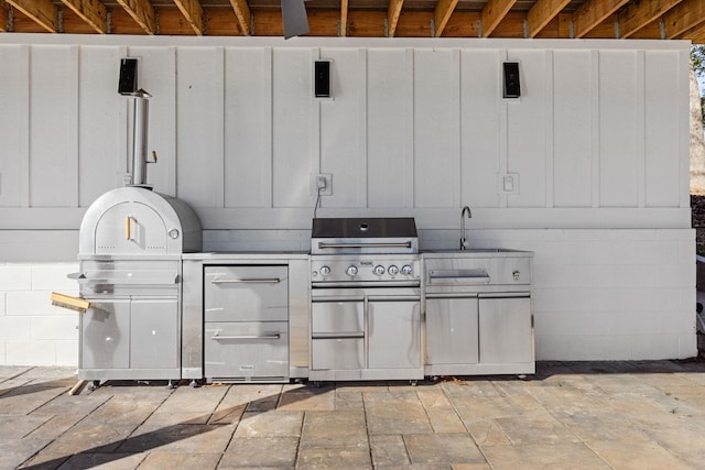 view of patio / terrace with an outdoor kitchen, a sink, and a grill