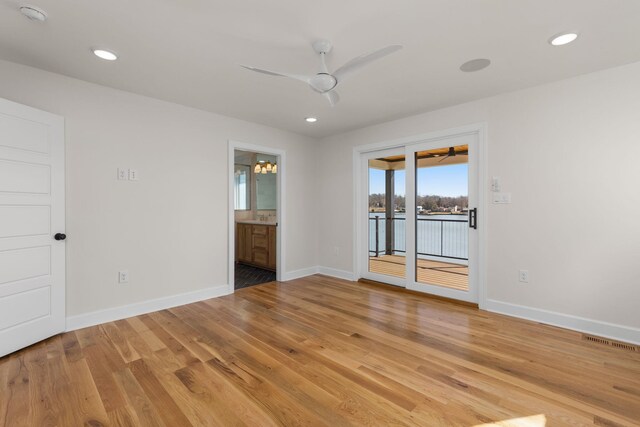 empty room featuring light wood-type flooring, baseboards, and recessed lighting