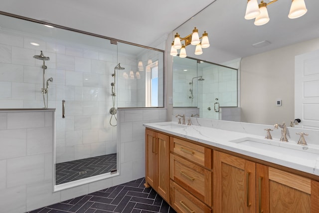 full bath featuring a stall shower, a sink, and double vanity