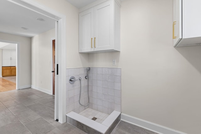 full bathroom with a shower stall and baseboards