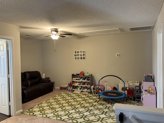 rec room featuring carpet, ceiling fan, and a textured ceiling