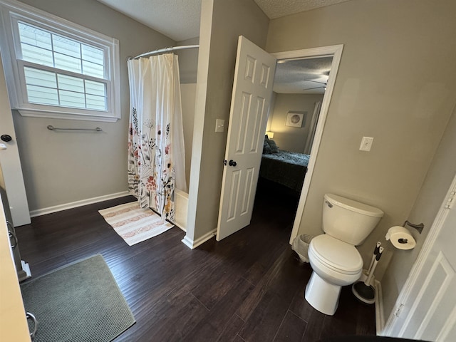 bathroom with a textured ceiling, ceiling fan, shower / bath combo with shower curtain, wood-type flooring, and toilet