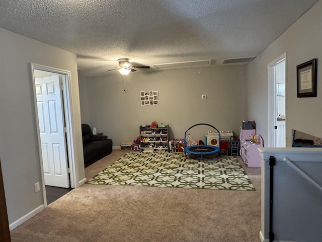 game room with ceiling fan, carpet, and a textured ceiling