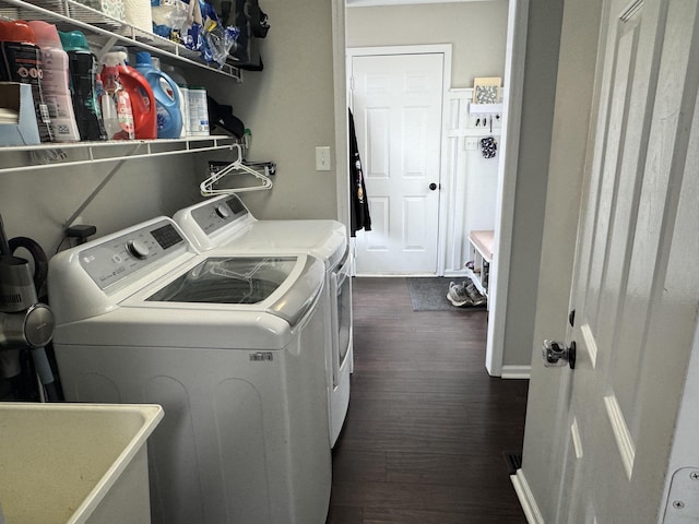 washroom with dark hardwood / wood-style flooring, washing machine and dryer, and sink