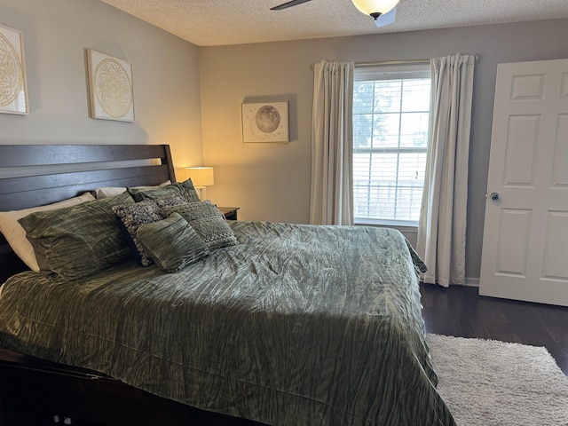 bedroom featuring ceiling fan, a textured ceiling, and multiple windows