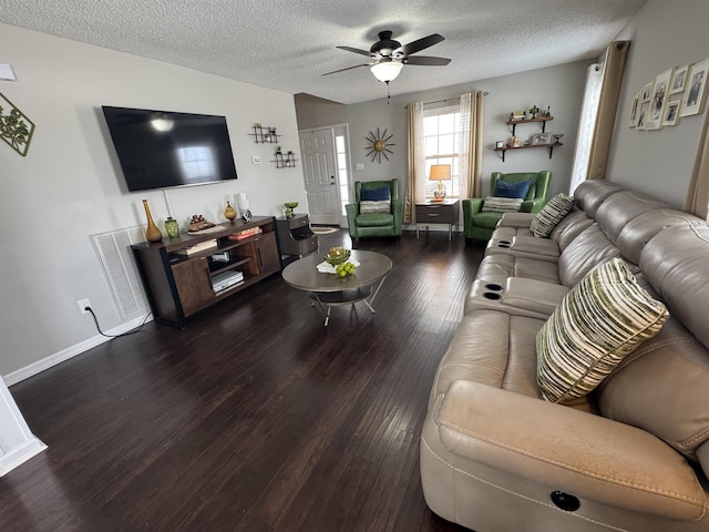 living room with ceiling fan, dark wood-type flooring, and a textured ceiling