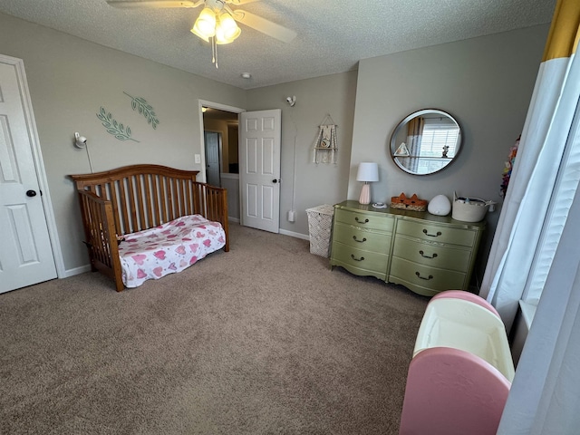 bedroom with light carpet, a textured ceiling, a crib, and ceiling fan