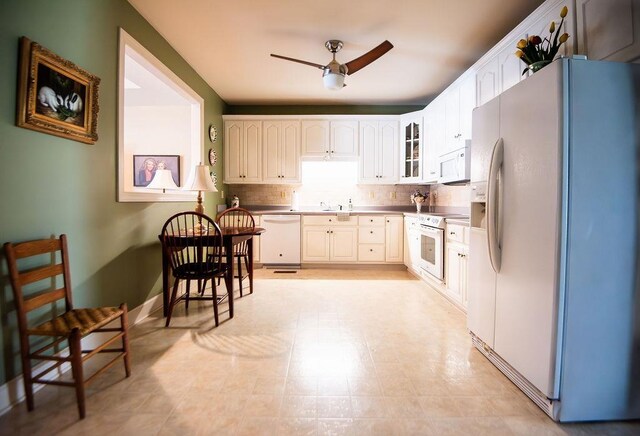  - kitchen with white appliances, ceiling fan, baseboards, glass insert cabinets, and decorative backsplash