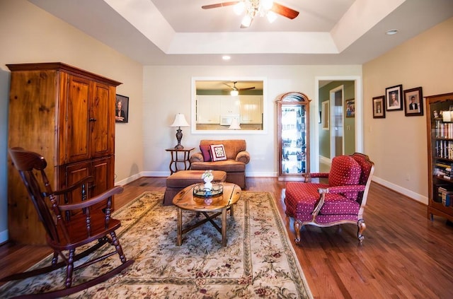  - sitting room featuring a raised ceiling, ceiling fan, baseboards, wood finished floors, and recessed lighting