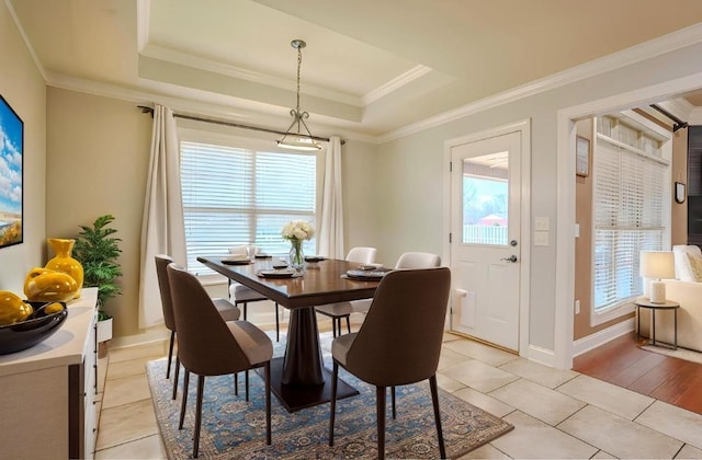  - dining space featuring light tile patterned floors, a tray ceiling, and ornamental molding