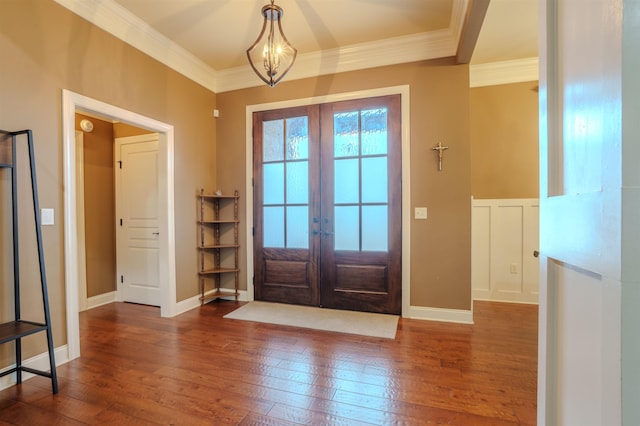 entryway with a notable chandelier, ornamental molding, dark hardwood / wood-style floors, and french doors