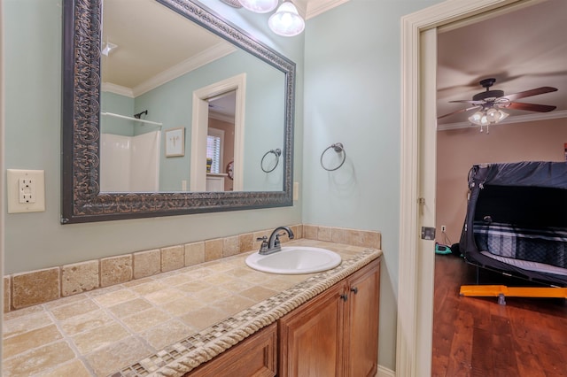 bathroom featuring vanity, ceiling fan, ornamental molding, and a shower