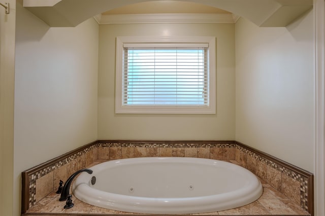 bathroom featuring ornamental molding and tiled tub