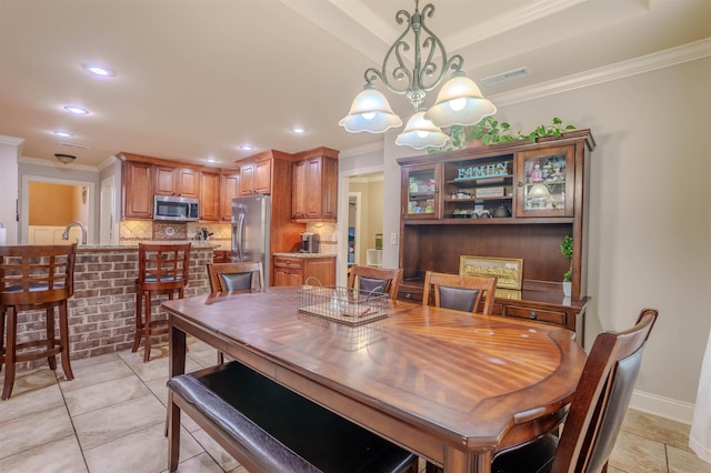 tiled dining area featuring crown molding and an inviting chandelier