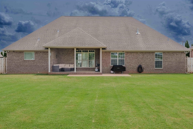  - back of house featuring a patio, a shingled roof, brick siding, and an outdoor living space