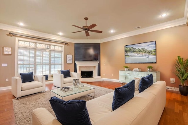  - living room featuring a ceiling fan, ornamental molding, a fireplace, wood finished floors, and recessed lighting