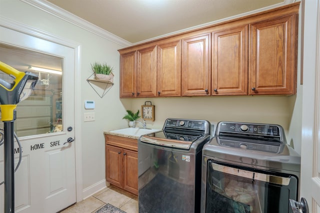  - washroom featuring washer and dryer, cabinet space, crown molding, and light tile patterned flooring