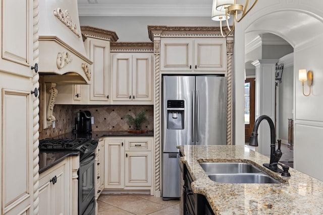 kitchen featuring backsplash, cream cabinets, sink, dark stone countertops, and stainless steel appliances