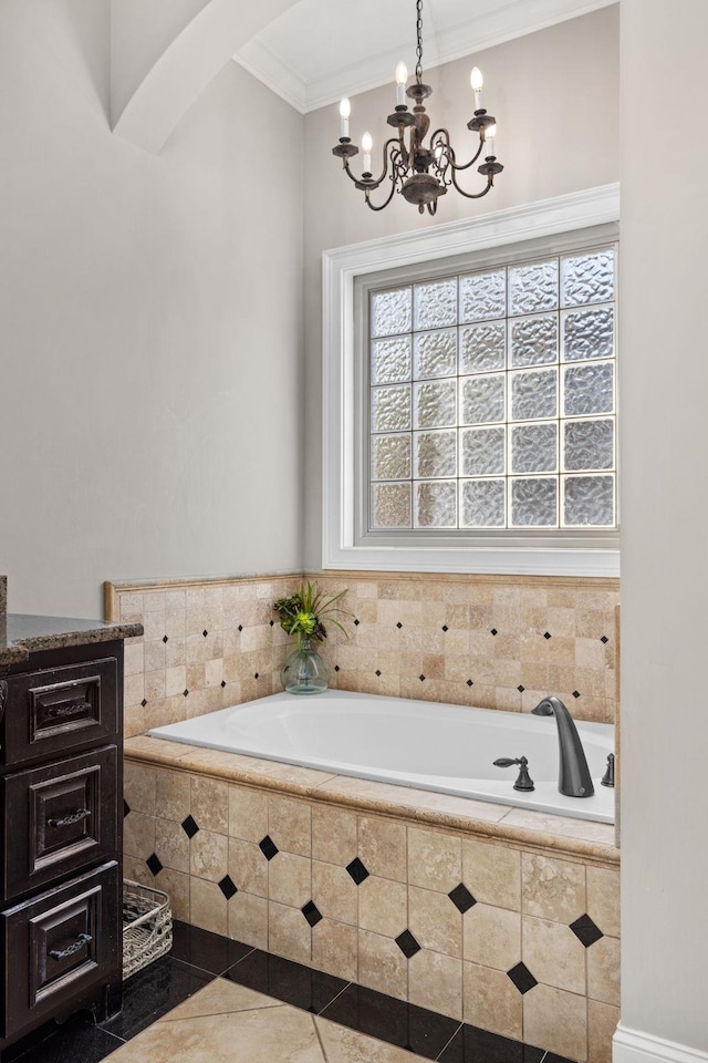 bathroom featuring tiled bath, tile patterned flooring, ornamental molding, and an inviting chandelier