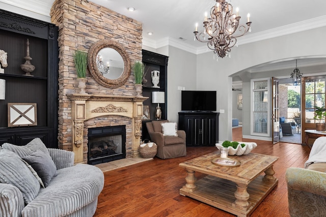 living room featuring hardwood / wood-style floors, a stone fireplace, and crown molding