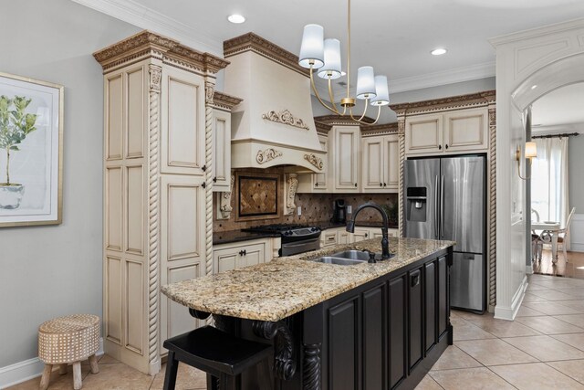 kitchen featuring a kitchen island with sink, cream cabinets, black range with gas stovetop, sink, and stainless steel fridge with ice dispenser