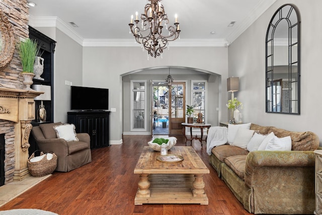 living room featuring a fireplace, ornamental molding, a notable chandelier, and hardwood / wood-style flooring