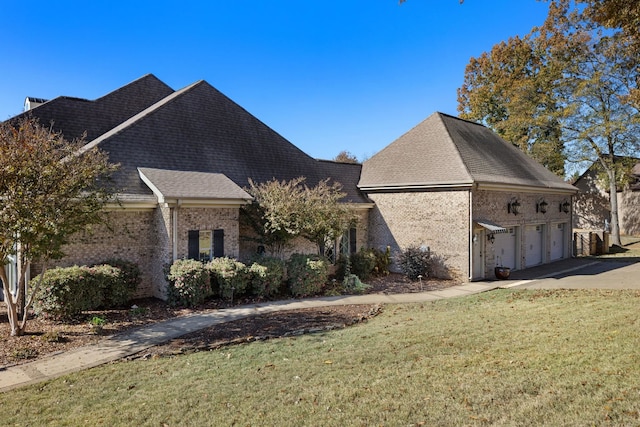 view of side of property with a garage and a lawn