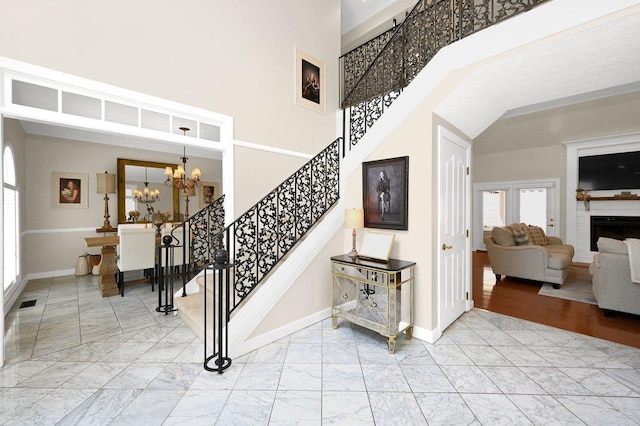 stairway featuring a towering ceiling and an inviting chandelier