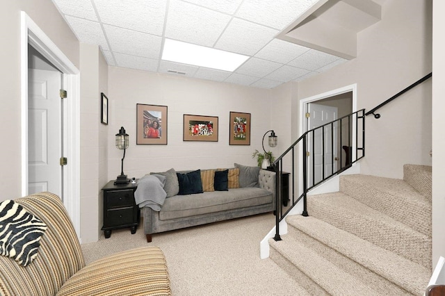 living room featuring a paneled ceiling and carpet floors