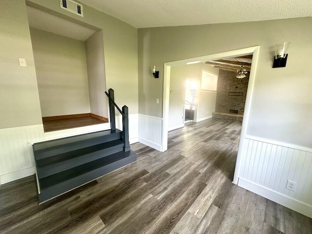  - stairway with wainscoting, wood finished floors, vaulted ceiling, and a ceiling fan