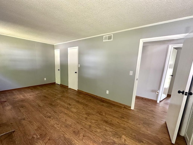 - unfurnished room featuring a textured ceiling, wood finished floors, crown molding, and baseboards