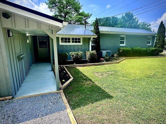  - view of grassy yard with central AC