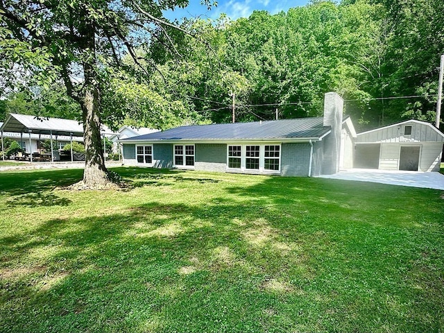  - ranch-style house featuring a chimney, a front lawn, and metal roof