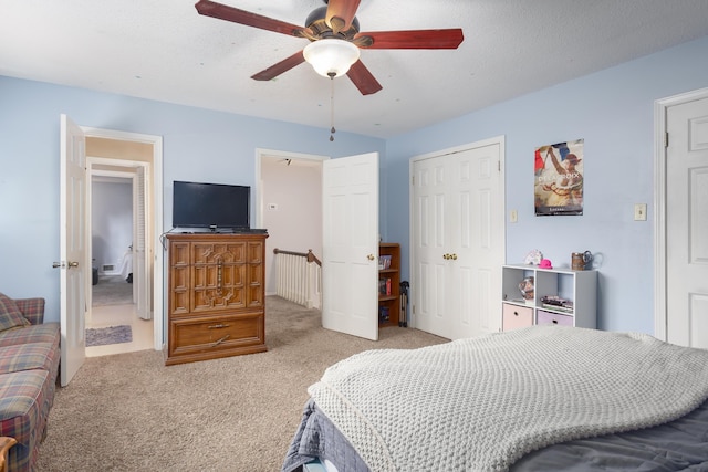 carpeted bedroom with a textured ceiling and ceiling fan