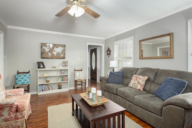 living room with dark hardwood / wood-style flooring, ceiling fan, and crown molding