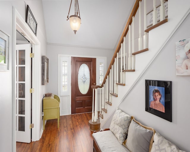 entryway with dark hardwood / wood-style flooring and crown molding