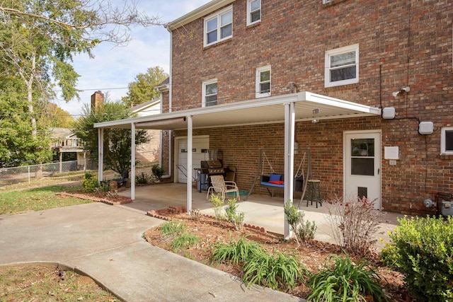 back of house featuring a patio area and a carport