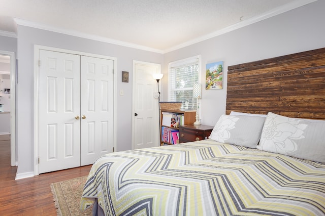 bedroom featuring a textured ceiling, ornamental molding, dark wood-type flooring, and a closet